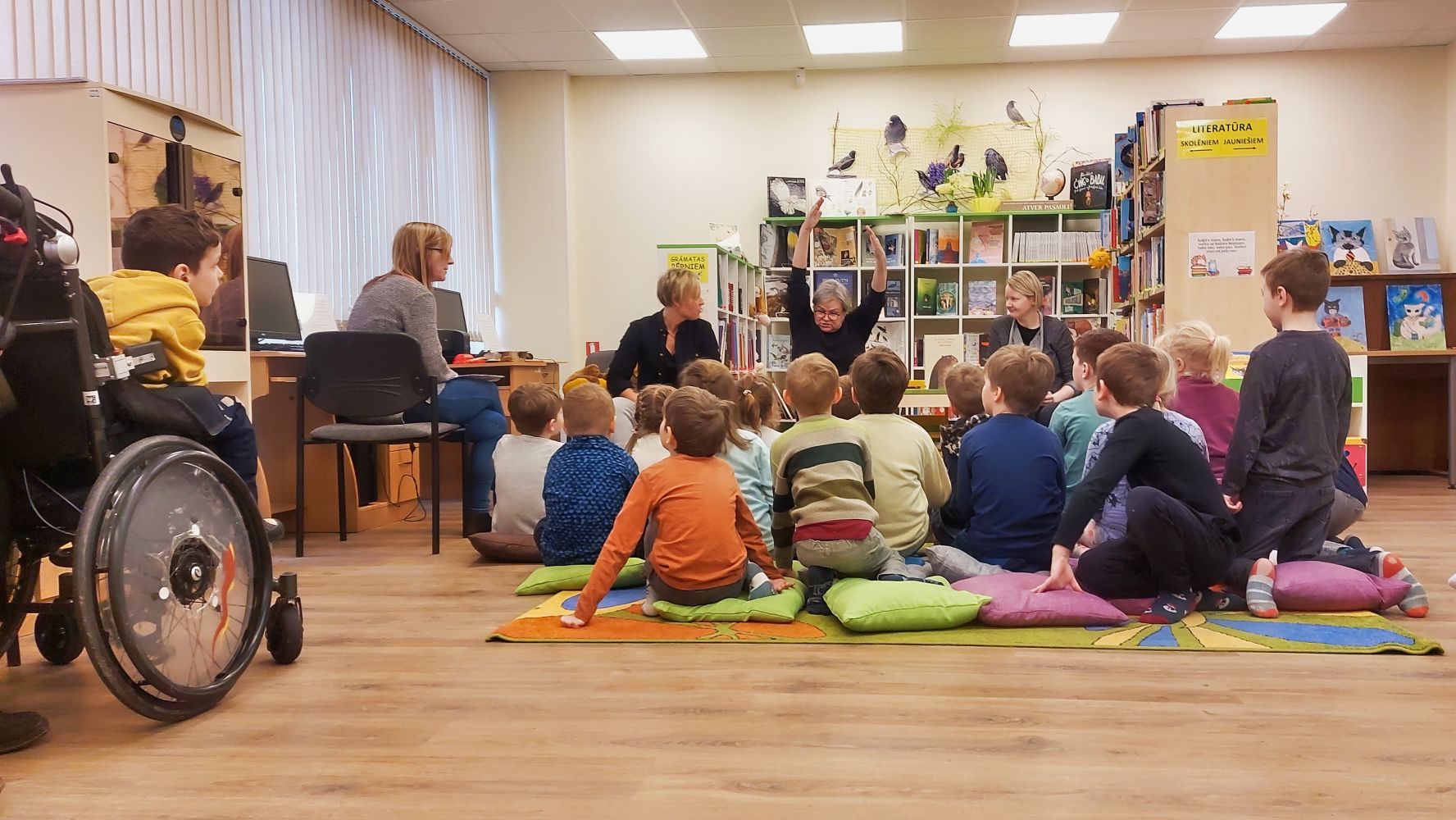 Bērni klausās bibliotekāru stāstījumā