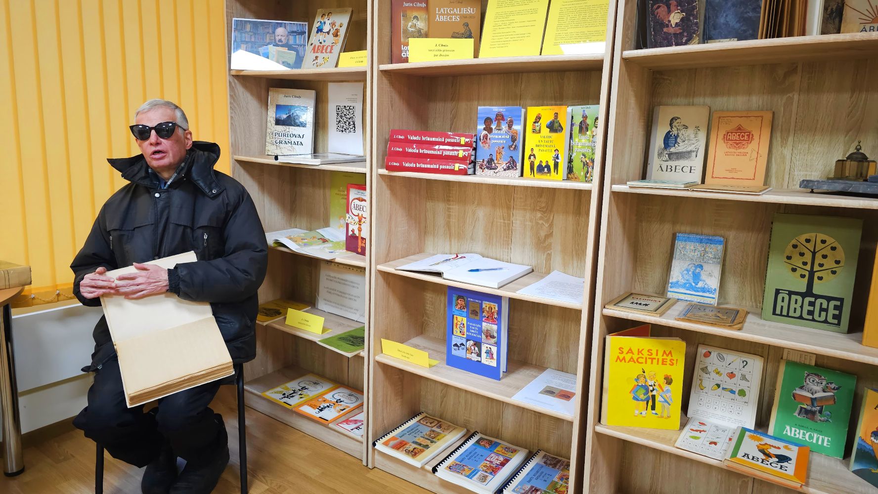 Apmeklētājs lasa ābeci Braila rakstā krievu valodā