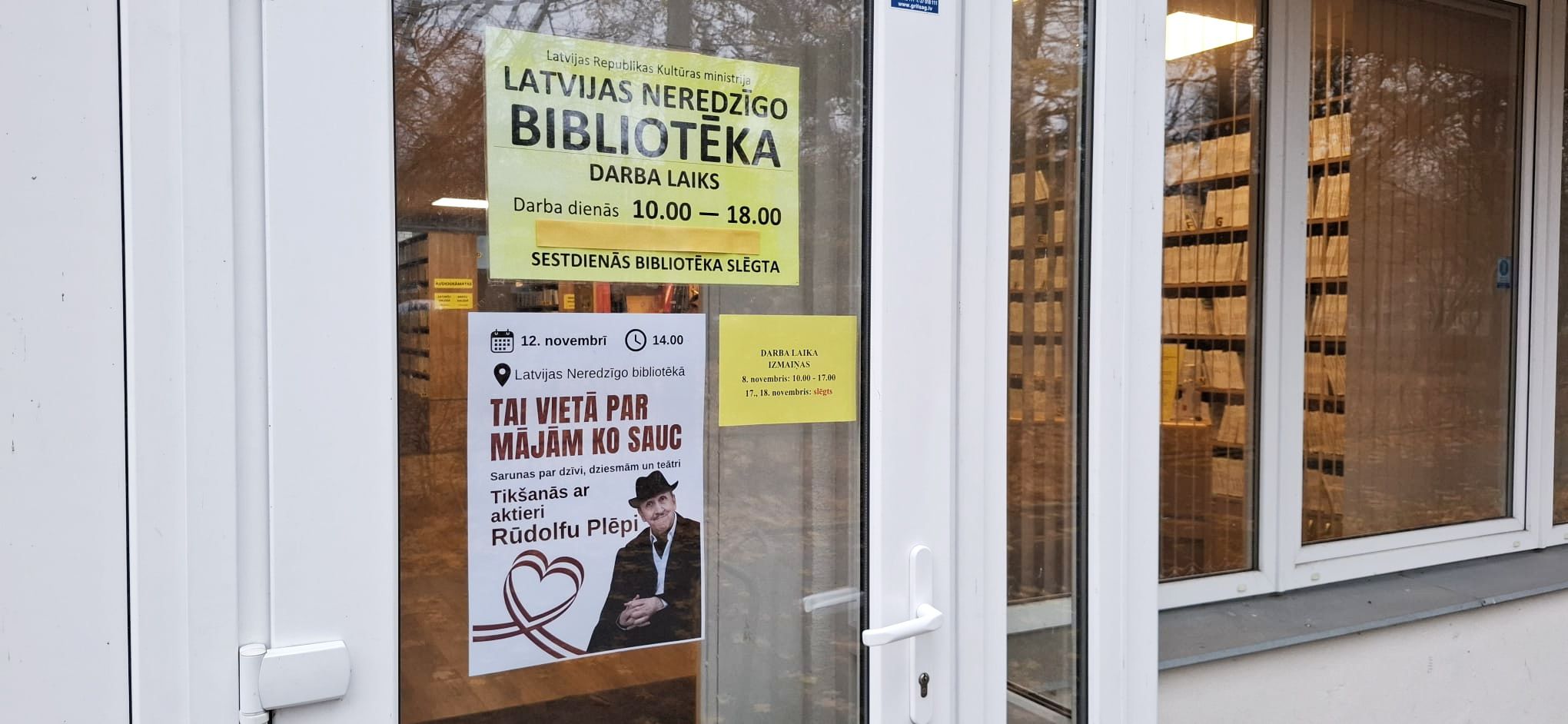 Pasākuma plakāts pie bibliotēkas durvīm