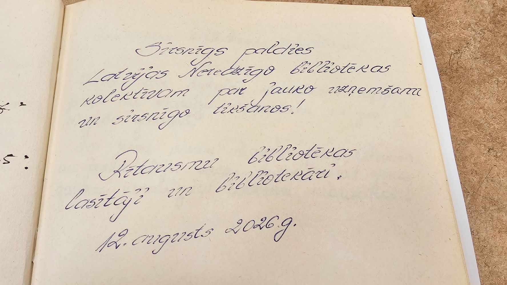 Ieraksts viesu grāmatā: "Sirsnīgs paldies Latvijas Neredzīgo bibliotēkas kolektīvam par jauko uzņemšanu un sirsnīgo tikšanos! Rītausmu bibliotēkas lasītāji un bibliotekāri. 12. augusts 2026.g."
